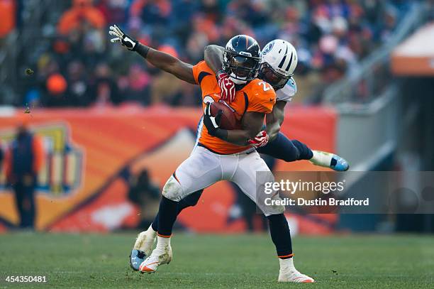 Running back Knowshon Moreno of the Denver Broncos is wrapped up and tackled by strong safety Bernard Pollard of the Tennessee Titans during a game...