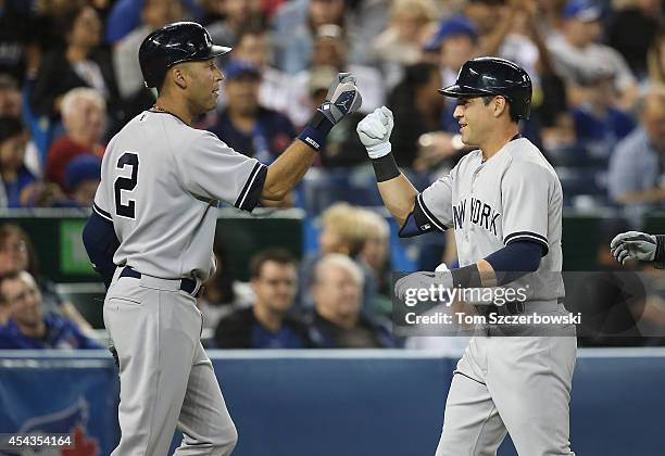 Jacoby Ellsbury of the New York Yankees is congratulated by Derek Jeter after hitting a two-run home run in the seventh inning during MLB game action...