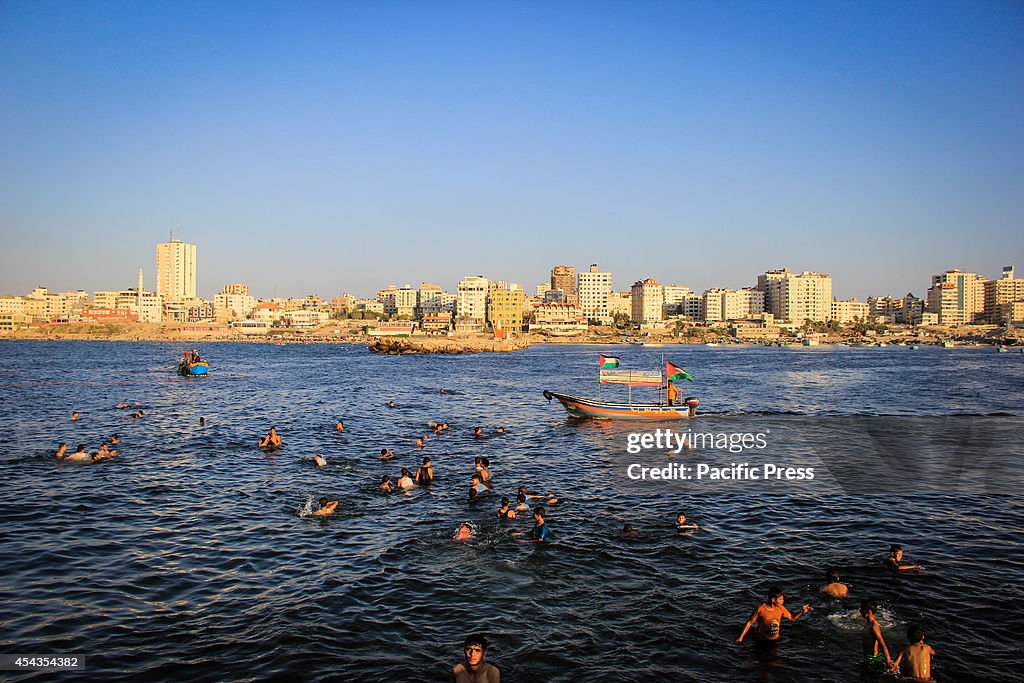 Palestinians gather and play in the Mediterranean Sea in...