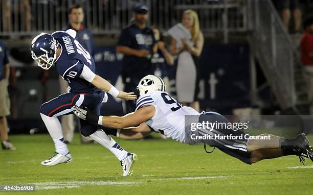 Connecticut quarterback Chandler Whitmer outruns a sack in the third quarter by BYU's Travis Tuiloma at Rentschler Field in East Hartford, Conn., on...