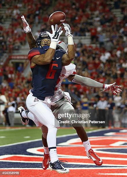 Running back Nate Phillips of the Arizona Wildcats is unable to catch a pass in the end zone guarded by defensive back Mike Horsey of the UNLV Rebels...