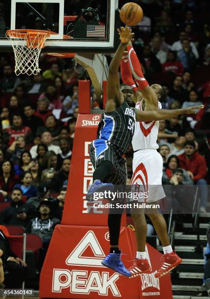 Dwight Howard of the Houston Rockets battles for a rebound with Jason Maxiell of the Orlando Magic at Toyota Center on December 8, 2013 in Houston,...