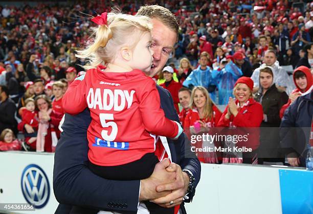 Retiring Swans player Ryan O'Keefe walks with his children on a lap of honour during the half time break of the round 23 AFL match between the Sydney...