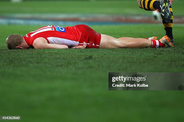 Zak Jones of the Swans lies injuried on the ground during the round 23 AFL match between the Sydney Swans and the Richmond Tigers at ANZ Stadium on...