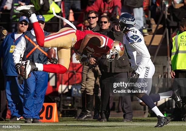 Wide receiver Michael Crabtree of the San Francisco 49ers snags a pass and heads for the ground in front of cornerback Byron Maxwell of the Seattle...