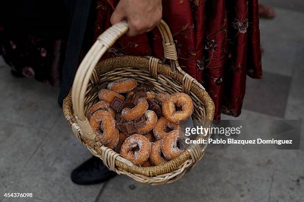Reveller dressed as a 'Ganchera' carries a basket of 'rosquillas' and chocolate to offer during the 'Gancheros' festival on August 30, 2014 in Poveda...