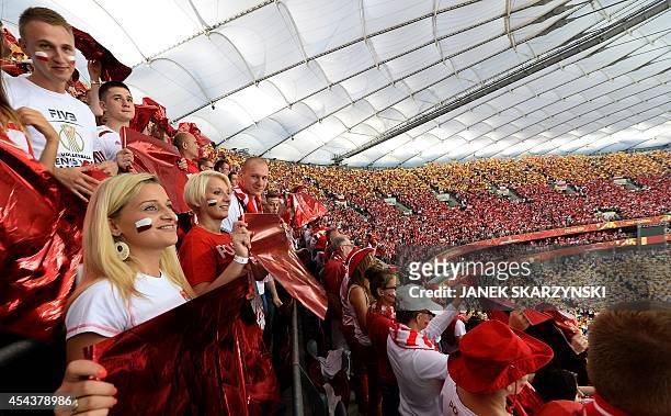 People hold red banners in the National Stadium in Warsaw during the opening ceremony of the FIVB Mens World Championship on August 30, 2014. AFP...