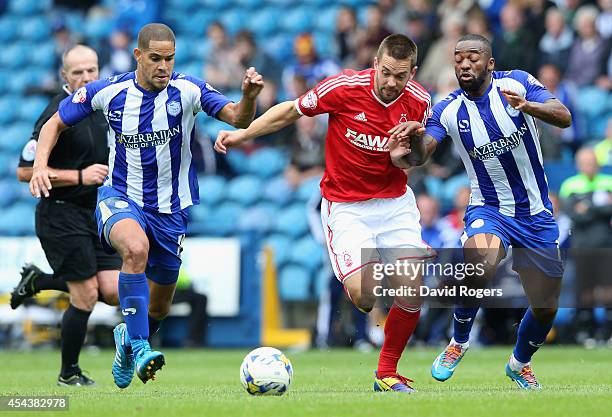 Matty Fryatt of Nottingham Forest is challenged by Giles Coke and Jacques Maghoma during the Sky Bet Championship match between Sheffield Wednesday...