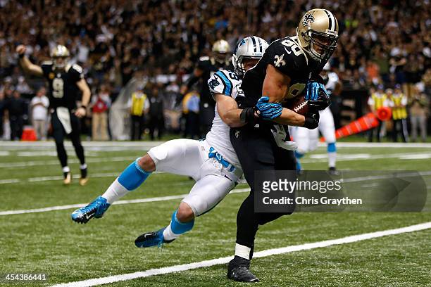 Jimmy Graham of the New Orleans Saints is tackled as he scores a touchdown by Luke Kuechly of the Carolina Panthers at Mercedes-Benz Superdome on...
