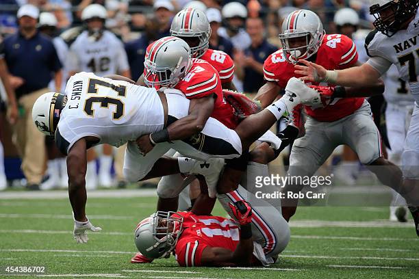 Safety Tyvis Powell of the Ohio State Buckeyes tackles fullback Chris Swain of the Navy Midshipmen during the second half at M&T Bank Stadium on...