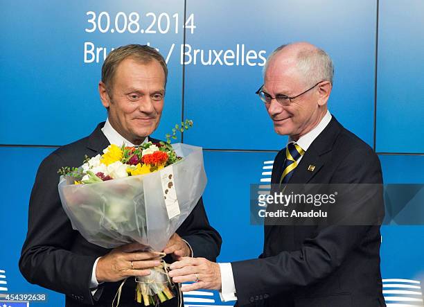 Polish Prime Minister Donald Tusk poses with a bouquet of flowers after being nominated new EU Council president as the outgoing European Council...