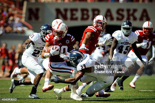 Wide receiver Kenny Bell of the Nebraska Cornhuskers is tackled by defensive back Sharrod Neasman of the Florida Atlantic Owls during their game at...
