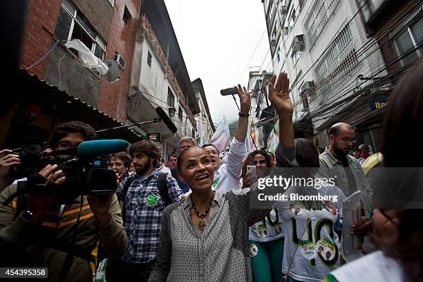 Marina Silva, Brazilian presidential candidate and former Senator, waves to supporters as she takes part in a rally in the Rocinha slum in Rio de...