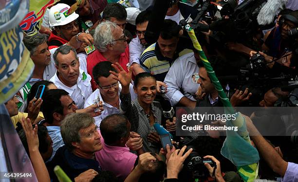 Marina Silva, Brazilian presidential candidate and former Senator, waves to supporters as she takes part in a rally in the Rocinha slum in Rio de...