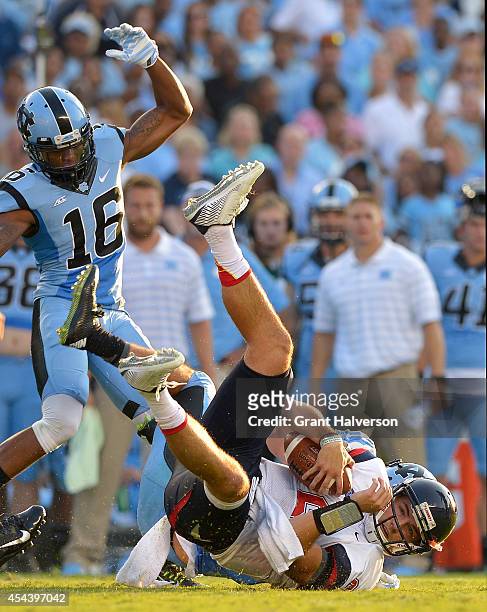 Jeff Schoettmer of the North Carolina Tar Heels tackles Josh Woodrum of the Liberty Flames during their game at Kenan Stadium on August 30, 2014 in...