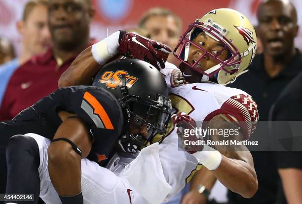 Rashad Greene of the Florida State Seminoles makes the catch as Kevin Peterson of the Oklahoma State Cowboys defends in the first half of the...