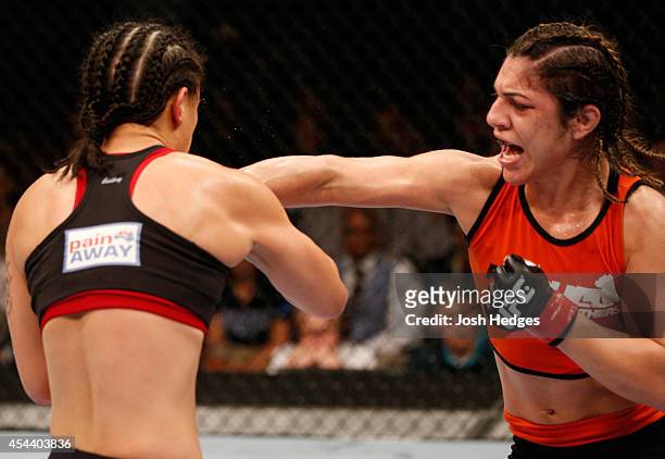 Bethe Correia of Brazil punches Shayna Baszler in their women's bantamweight bout during the UFC 177 event at Sleep Train Arena on August 30, 2014 in...