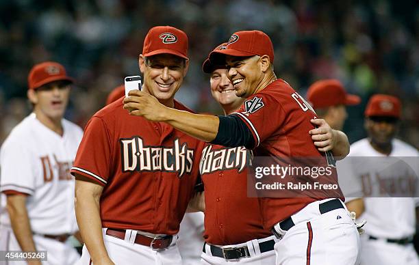 Former Arizona Diamondbacks players Luis Gonzalez, Jason Conti and Alex Cintron take a selfie before the start of the Diamondbacks Alumni Game at...