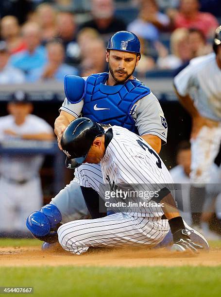 Ichiro Suzuki of the New York Yankees is tagged out by George Kottaras of the Kansas City Royals trying to score on a first inning passed ball at...