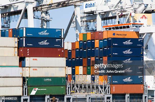 Cargo containers being loaded onto a freighter ship.