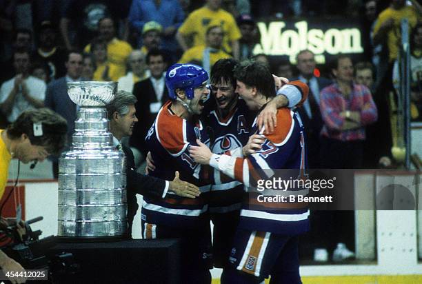 Mark Messier of the Edmonton Oilers celebrates with teammates Kevin Lowe and Jari Kurri after Game 5 of the 1990 Stanley Cup Finals against the...