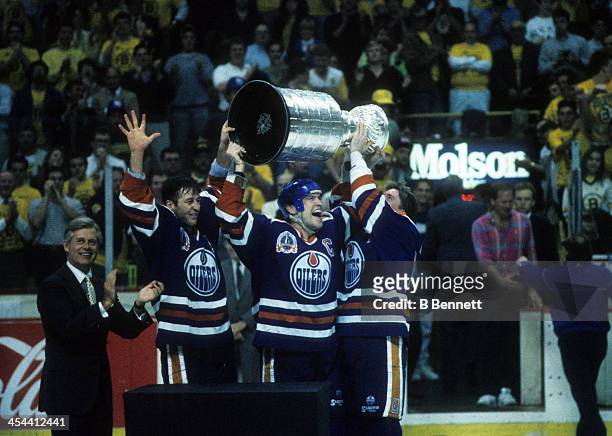 Mark Messier of the Edmonton Oilers celebrates with teammates Kevin Lowe and Jari Kurri after Game 5 of the 1990 Stanley Cup Finals against the...