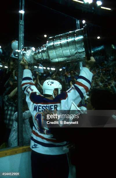 Mark Messier of the Edmonton Oilers skates around the rink celebrating with the crowd while holding the Stanley Cup Trophy after Game 7 of the 1987...