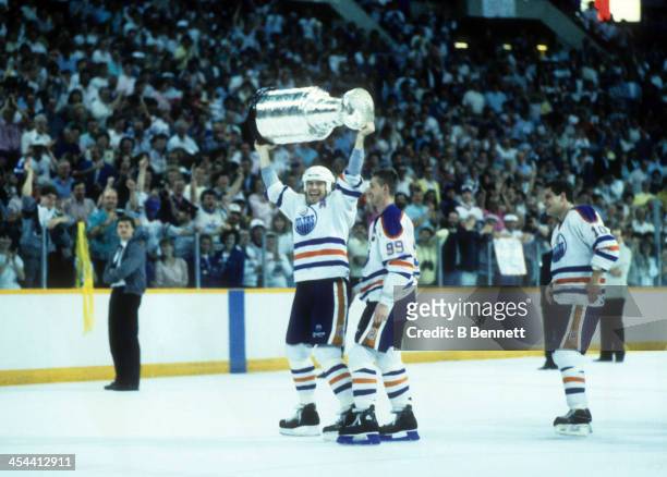 Mark Messier, Wayne Gretzky and Esa Tikkanen of the Edmonton Oilers celebrate with Stanley Cup Trophy after Game 4 of the 1988 Stanley Cup Finals...
