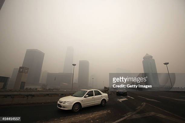 Vehicles are driven along a road during heavily polluted weather on December 8, 2013 in Beijng, China. Heavy smog has been lingering in northern and...