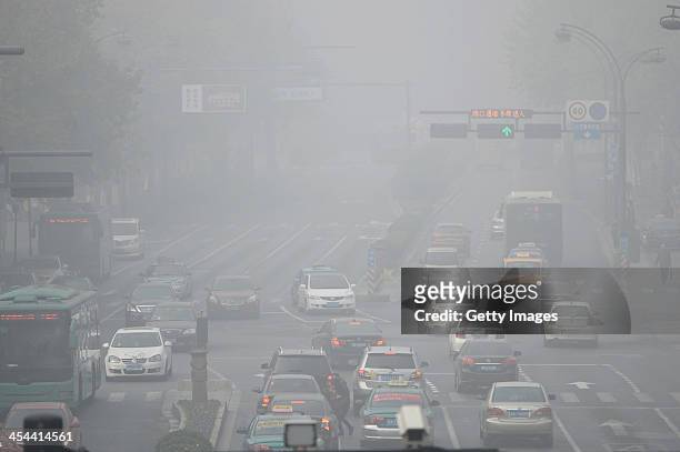 Vehicles are driven along a road on December 8, 2013 in Hangzhou, China. Heavy smog has been lingering in northern and eastern parts of China since...