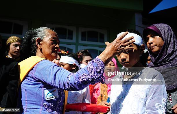 Dieng's religious leader blesses a dreadlock kid during Ruwatan Rambut Gimbal ceremony on August 31, 2014 in Dieng, Java, Indonesia. The Dieng...