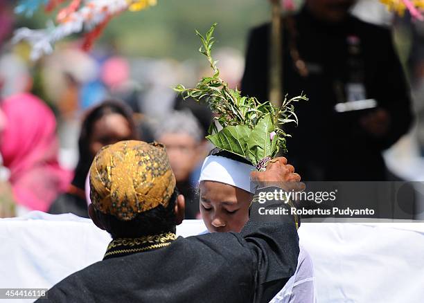 Child participates in the Jamasan ritual as part of Ruwatan Rambut Gimbal ceremony on August 31, 2014 in Dieng, Java, Indonesia. The Dieng Culture...