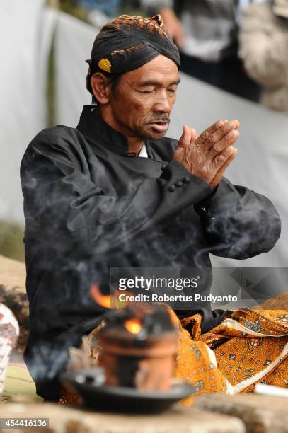 Dieng's religious leader prays during the Larung ritual as part of Ruwatan Rambut Gimbal ceremony on August 31, 2014 in Dieng, Java, Indonesia. The...