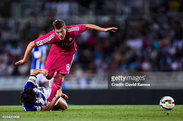 Toni Kroos of Real Madrid CF competes for the ball with Esteban Granero of Real Sociedad during the La Liga match between Real Sociedad de Futbol and...