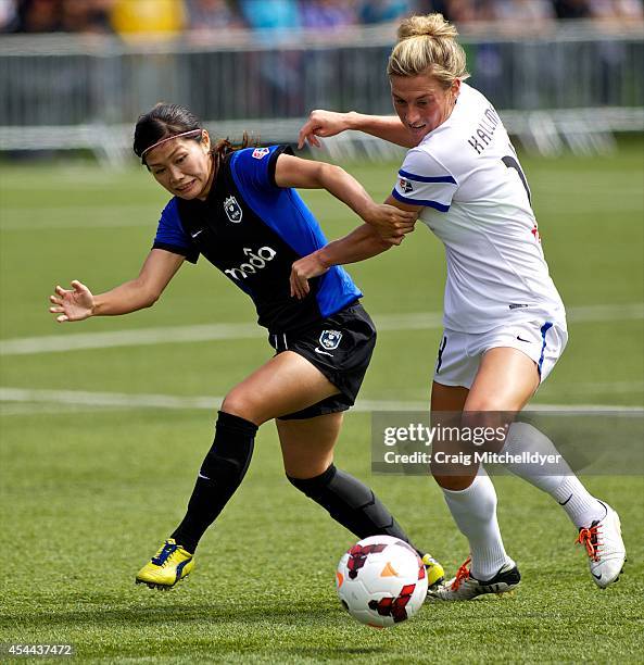 Nahomi Kawasumi of Seattle Reign FC controls the ball against Kassey Kallman of FC Kansas City in the first half of the National Women's Soccer...