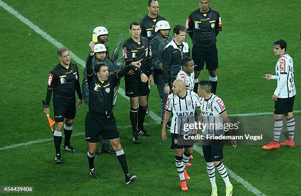 Referee Paulo H Godoy Bezerra shows Luciano of Corinthians the yellow card during the match between Corinthians and Fluminense for the Brazilian...