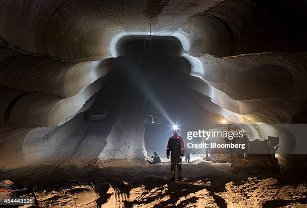 Bloomberg's Best Photos 2013: An employee uses the light from a head torch to illuminate the machine cut walls of a potash mine operated by OAO...