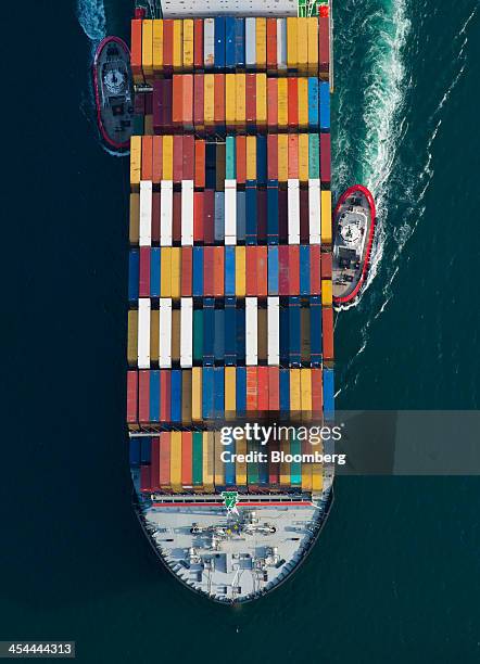 Bloomberg's Best Photos 2013: Tugboats help guide a Mediterranean Shipping Co. Ship loaded with freight containers in this aerial photograph...