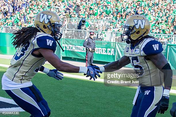 Troy Stoudermire and Don Unamba of the Winnipeg Blue Bombers celebrate after a touchdown in a game between the Winnipeg Blue Bombers and Saskatchewan...