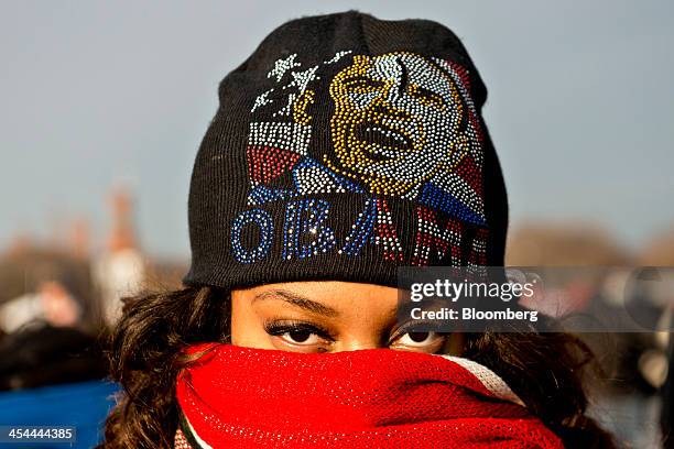 Bloomberg's Best Photos 2013: Shantrese Davis, from New Orleans, Louisiana, wears a hat with an image of President Barack Obama to keep warm on the...