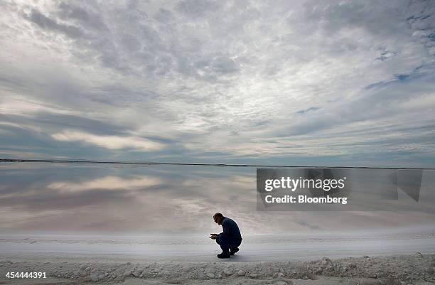 Bloomberg's Best Photos 2013: Biologist Fernando Heredia inspects the quality of a crystallization pond at the Exportadora de Sal harvest fields in...