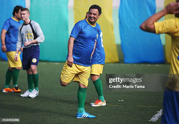 Presidential candidate Aecio Neves of the Brazilian Social Democracy Party stretches at a campaign soccer match at the Zico Football Center on August...