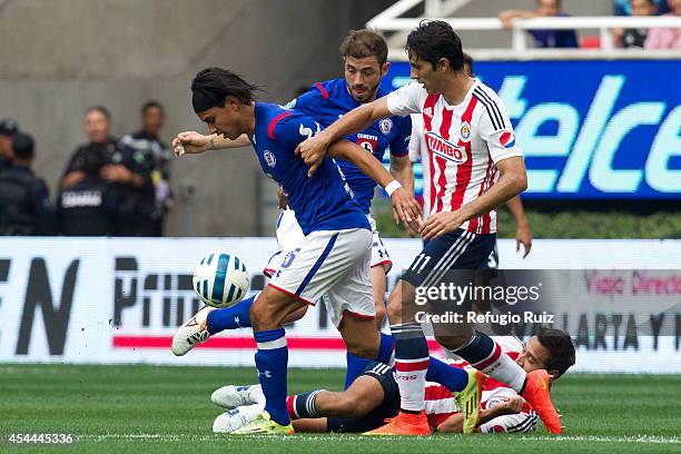 Aldo de Nigris of Chivas is dribbled by Gerardo Floresof Cruz Azul during a match between Chivas and Cruz Azul a as part of Apertura 2014 Liga MX at...