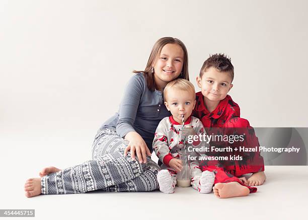 siblings in christmas pyjamas - hazel bond fotografías e imágenes de stock