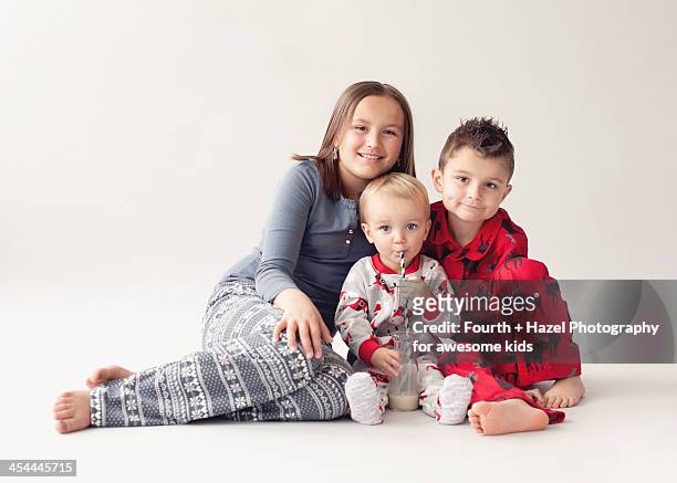 siblings in christmas pyjamas - hazel bond stock pictures, royalty-free photos & images