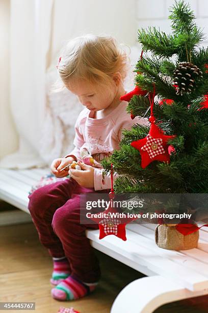 cute little girl decorating little furtree at home - eenjarig plantenkenmerk stockfoto's en -beelden