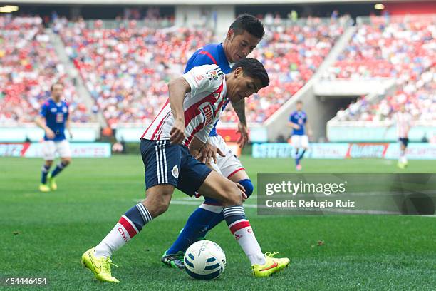 Jesus Sanchez of Chivas fights for the ball with Rogelio Chavez of Cruz Azul during a match between Chivas and Cruz Azul a as part of Apertura 2014...