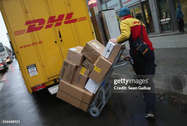 Worker of DHL delivers packages during the busy Christmas season on December 9, 2013 in Berlin, Germany. According to a recent study people in...