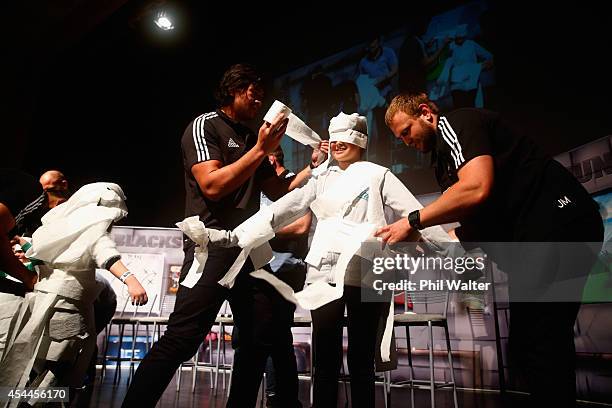 Steven Luatua and Joe Moody of the All Blacks dress a young fan in toilet paper to design a wedding dress during a New Zealand All Blacks community...