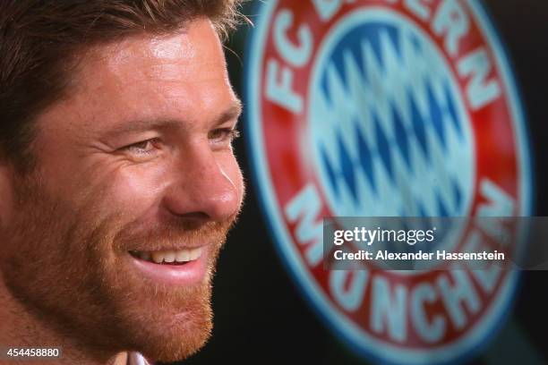 Xabi Alonso of FC Bayern Muenchen smiles during a press conference at Bayern Muenchen's headquarter Saebener Strasse on September 1, 2014 in Munich,...